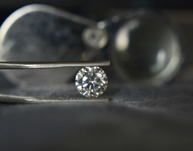 Kontroll av diamant och infattning vid smyckesvård i Guldsmedshusets verkstad